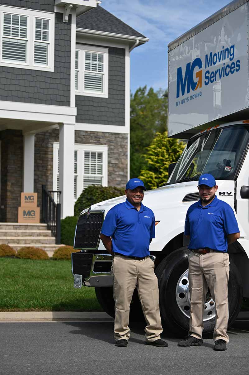 MG Moving services team in front of a house