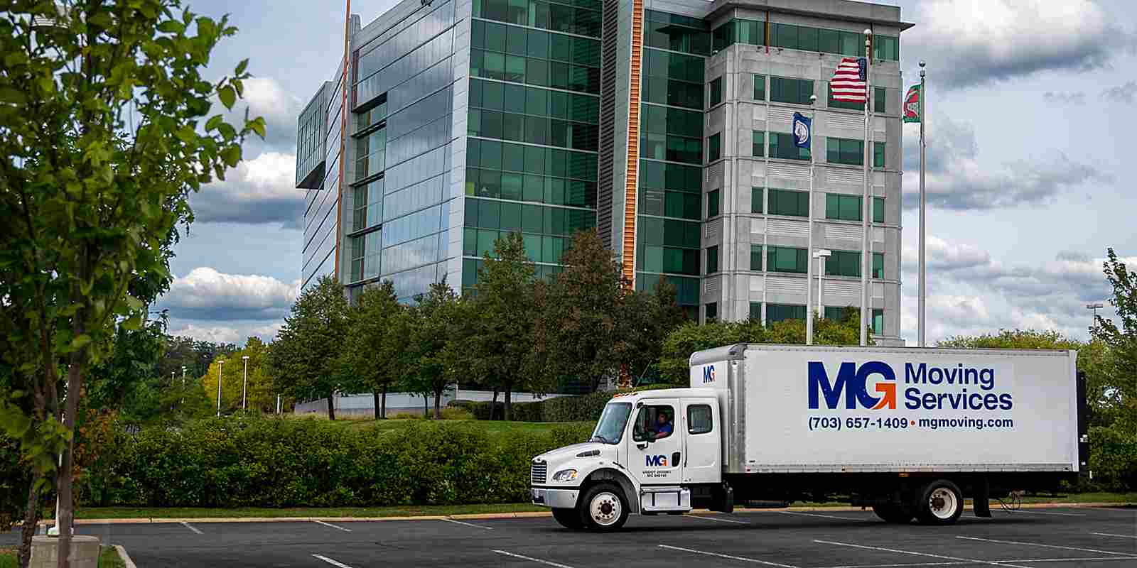 MG Moving truck parked in front of building ready for a commercial move