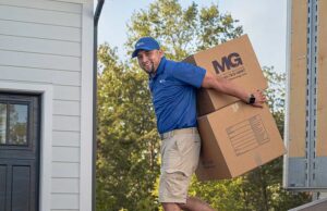 mg moving services employee moving furniture boxes into a home