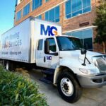 mg moving truck outside of a commercial office building