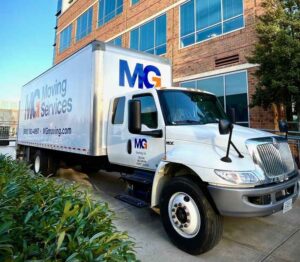 mg moving truck outside of a commercial office building