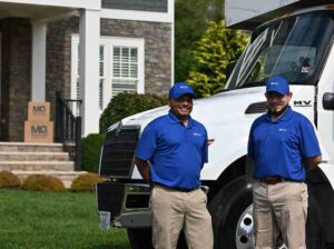 professional movers by truck in front of house